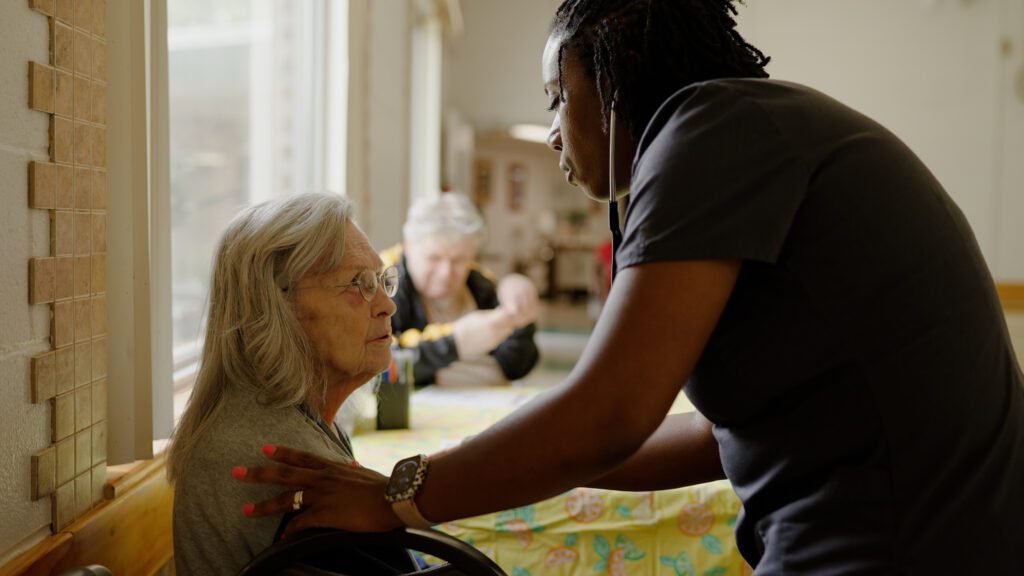 A nurse assists a woman with a check up at a skilled nursing home
