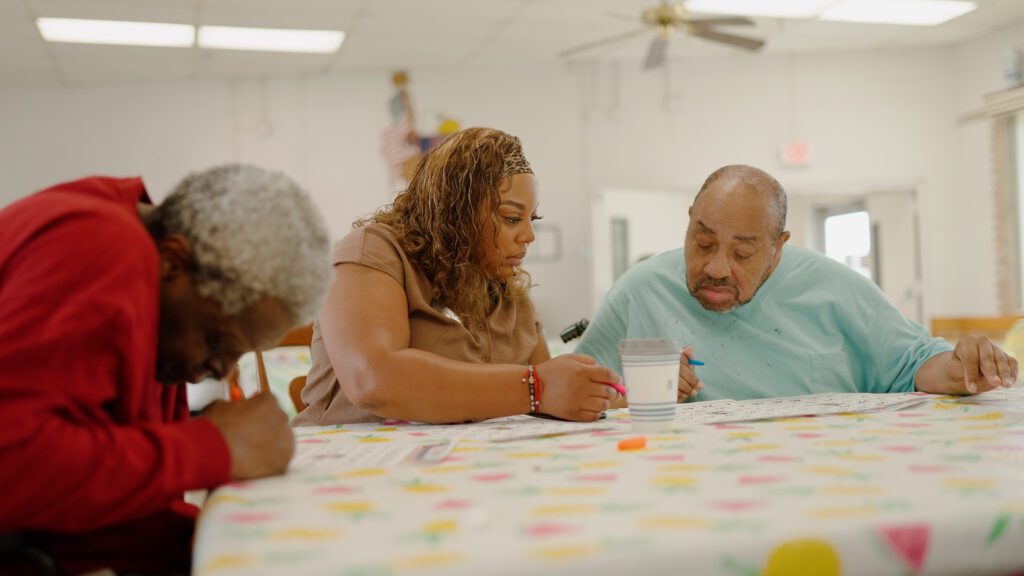 A nurse assists residents at a skilled nursing facility with an activity